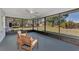 Screened patio with wood chairs and a clear view of the serene backyard at 4512 Ulster Ave, North Port, FL 34287
