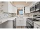 Modern kitchen featuring white cabinets and hexagon backsplash at 3661 Lake Bayshore Dr # 507J, Bradenton, FL 34205