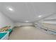 Bright attic storage room with shelving units and carpeted floor at 4674 Hidden River Rd, Sarasota, FL 34240
