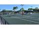 Tennis court with players and lush landscaping at 4640 Tower Hill Ln # 2322, Sarasota, FL 34238