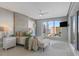 Bright bedroom features a neutral palette, accent wall, and serene water views from the large windows at 35 Watergate Dr # 503, Sarasota, FL 34236
