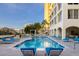 A resort style pool features lounge chairs, a pool, and a building in the background, perfect for relaxation and entertainment at 35 Watergate Dr # 503, Sarasota, FL 34236