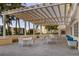 A sheltered pool terrace with tables and seating provides a relaxing area with tropical landscaping at 35 Watergate Dr # 503, Sarasota, FL 34236