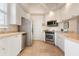 Modern kitchen featuring white cabinets, stainless steel appliances and tile flooring at 5814 Benevento Dr, Sarasota, FL 34238