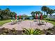 Community patio with tables, chairs, and umbrellas near a lake at 5814 Benevento Dr, Sarasota, FL 34238
