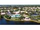 Community pool, tennis courts, and clubhouse near a lake at 5814 Benevento Dr, Sarasota, FL 34238