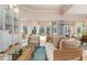 Bright living room with wicker furniture, a large window, and access to a screened patio at 5814 Benevento Dr, Sarasota, FL 34238