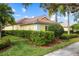 Side view of a yellow house with well-manicured hedges at 5814 Benevento Dr, Sarasota, FL 34238