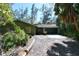Ranch style home with green exterior, attached garage, and mature landscaping at 600 Dream Island Rd, Longboat Key, FL 34228