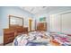 Bedroom with mirrored dresser and floral bedding at 5050 Hanging Moss Ln, Sarasota, FL 34238