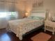 Bright bedroom with floral bedding and hardwood floors at 1310 Glen Oaks E Dr # 182E, Sarasota, FL 34232