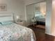 Bright bedroom with mirrored closet doors and floral bedding at 1310 Glen Oaks E Dr # 182E, Sarasota, FL 34232