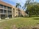 Two-story condo building with green lawn and palm trees at 1310 Glen Oaks E Dr # 182E, Sarasota, FL 34232