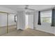 Well-lit bedroom with mirrored closet doors and ceiling fan at 5188 Marsh Field Ln # 93, Sarasota, FL 34235