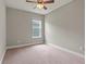 Bright bedroom with carpeted floor, ceiling fan, and window at 18901 Muhly Grass Ln, Lutz, FL 33558