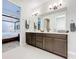 Double vanity bathroom with modern light fixtures and a large mirror at 8678 Rain Song Rd, Sarasota, FL 34238
