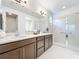 Bathroom with double vanity, walk-in shower, and separate toilet area at 8678 Rain Song Rd, Sarasota, FL 34238