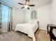 Bright bedroom with a queen bed, ceiling fan, and window curtains at 8678 Rain Song Rd, Sarasota, FL 34238