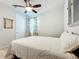 Spacious bedroom with a queen bed, ceiling fan, and window curtains at 8678 Rain Song Rd, Sarasota, FL 34238