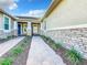 Home exterior with stone accents, a well-maintained walkway, and manicured landscaping at 8678 Rain Song Rd, Sarasota, FL 34238