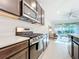Modern kitchen showcasing stainless steel appliances, a gas range, and a view into the living room at 8678 Rain Song Rd, Sarasota, FL 34238
