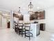 Open kitchen with a large island, pendant lighting, stainless steel appliances, and barstool seating at 8678 Rain Song Rd, Sarasota, FL 34238