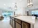 Modern kitchen with a large island, quartz countertops, pendant lighting, and stainless steel appliances at 8678 Rain Song Rd, Sarasota, FL 34238