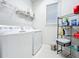 Laundry room with washer, dryer, and storage shelving at 8678 Rain Song Rd, Sarasota, FL 34238