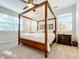 Spacious bedroom with a four poster bed and plenty of natural light at 8678 Rain Song Rd, Sarasota, FL 34238