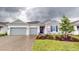 Two-car garage home with gray siding and blue shutters at 1575 Laurel Brook Ln, Port Charlotte, FL 33953