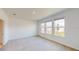 Well-lit bedroom featuring three windows and plush carpeting at 16113 Old Fox Trl, Port Charlotte, FL 33953