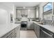 Modern kitchen with gray cabinets, quartz countertops, and stainless steel appliances at 6328 Winding Pine Dr, Nokomis, FL 34275
