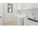Laundry room with white cabinets, sink, and washer/dryer at 524 Bocelli Dr, North Venice, FL 34275