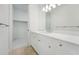 Bright bathroom boasts a white vanity, quartz countertop, and an adjacent walk-in closet at 524 Bocelli Dr, North Venice, FL 34275