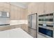 Modern kitchen with stainless steel appliances and light beige cabinets at 524 Bocelli Dr, North Venice, FL 34275