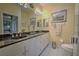 Well-lit bathroom featuring double sinks, granite counters, and a large mirror at 8047 Victoria Falls Cir, Sarasota, FL 34243