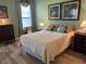 Cozy bedroom features a comfortable bed, calming green walls, and bright natural light at 8047 Victoria Falls Cir, Sarasota, FL 34243
