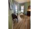 Light-filled bedroom with wood-look floors, inviting sitting area, and calming green walls at 8047 Victoria Falls Cir, Sarasota, FL 34243