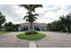 Exterior of clubhouse featuring stucco walls, arched entryways, tiled roof and landscaped circular driveway at 8047 Victoria Falls Cir, Sarasota, FL 34243