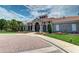 Exterior of clubhouse featuring stucco walls, arched entryways, tiled roof and landscaped circular driveway at 8047 Victoria Falls Cir, Sarasota, FL 34243