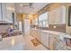 Well-lit kitchen showcases white cabinets, tile backsplash, modern appliances, and breakfast nook at 8047 Victoria Falls Cir, Sarasota, FL 34243