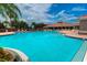 Community pool with a clear blue surface, lounge chairs, umbrellas, and a spacious sun deck at 8047 Victoria Falls Cir, Sarasota, FL 34243