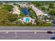 Aerial view of community featuring pool, lake, and numerous buildings at 370 Three Lakes Ln # F, Venice, FL 34285