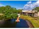 Aerial view of a community with a pond, dock, and pool; lush landscaping surrounds the buildings at 370 Three Lakes Ln # F, Venice, FL 34285