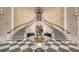 Elegant two-story lobby with double staircases, checkered floors, and a chandelier at 401 N Point Rd # 301, Osprey, FL 34229