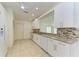 White kitchen features granite countertops and tile flooring at 5372 Pamela Wood Way # 7, Sarasota, FL 34233
