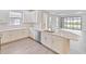 Open concept kitchen with white cabinets, stainless steel appliances and views to backyard at 4769 Tortona Ct, Bradenton, FL 34211