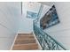Staircase with teal railing and ocean-themed artwork at 118 Mangrove Ave, Anna Maria, FL 34216