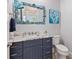 Small bathroom with a unique seashell mirror and navy vanity at 118 Mangrove Ave, Anna Maria, FL 34216