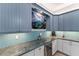 Kitchen features blue cabinets, granite counters, and wine cooler at 118 Mangrove Ave, Anna Maria, FL 34216